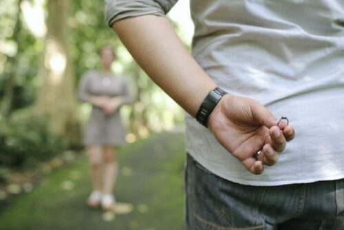 man holding ring behind back