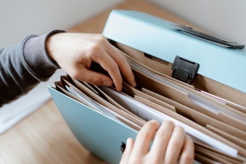 person looking through file folder