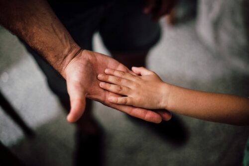 child's hand on a parents hand
