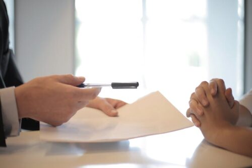 man holding pen and paper