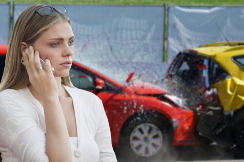 woman on phone in front of accident