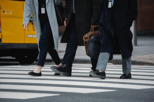 three people walking in a crosswalk