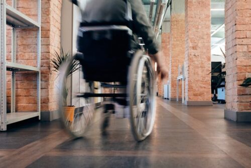 person moving down hallway in wheel chair