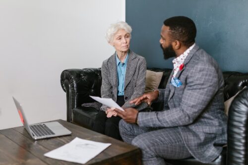 older woman talking with younger man in suit