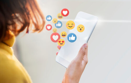 Woman using a mobile phone with emoticons
